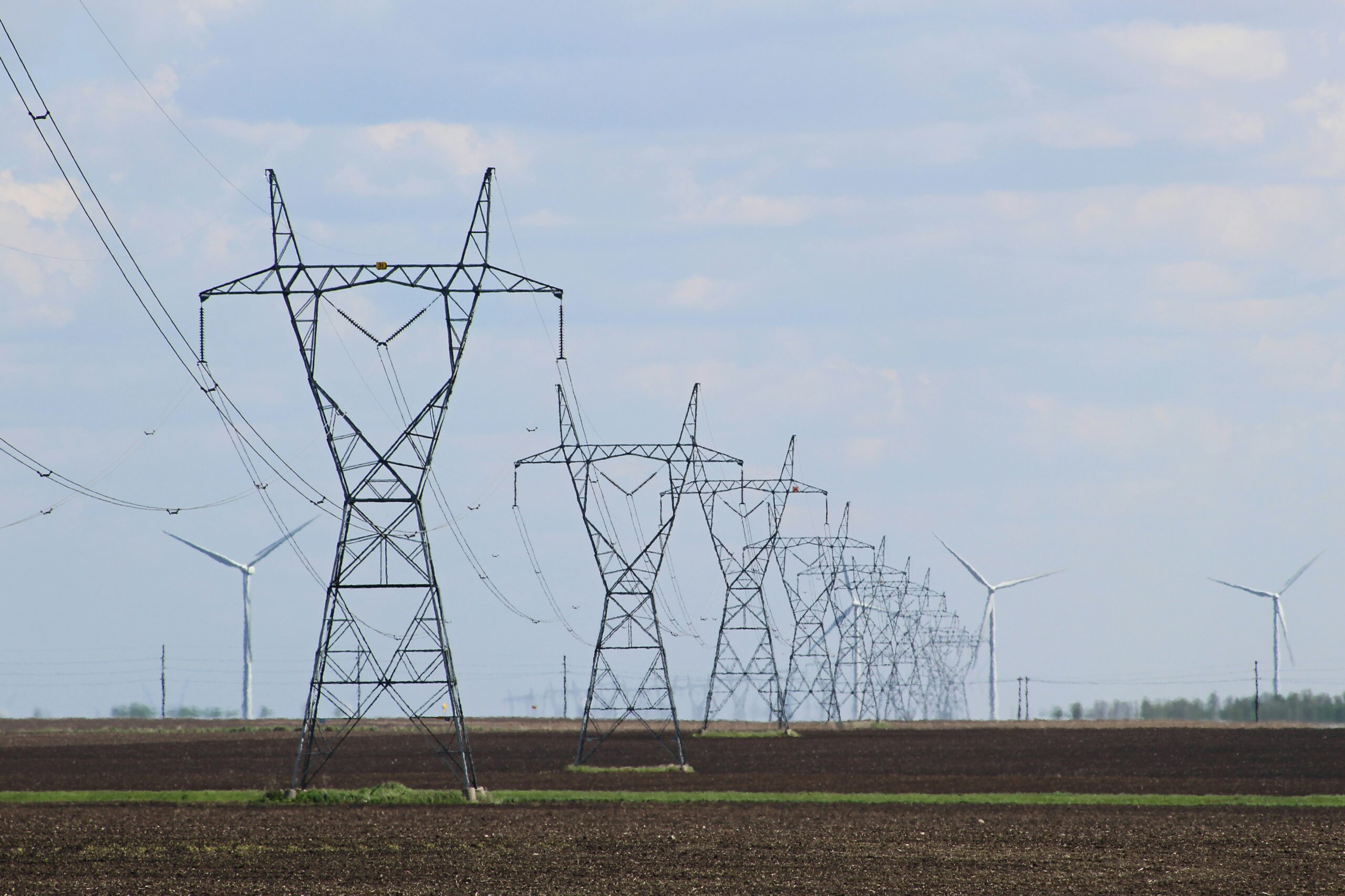 A row of transmission lines. Transmission lines construction is affected by social license to operate.